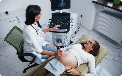 Doctor examining pregnant woman with stethoscope