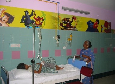 Child with IV and woman in hospital ward with cartoon mural.