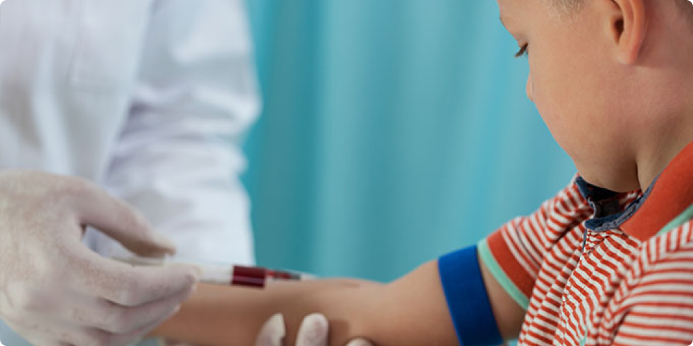 Medical professional drawing blood from a child's arm.
