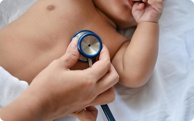 Pediatric cardiologist examining child with stethoscope
